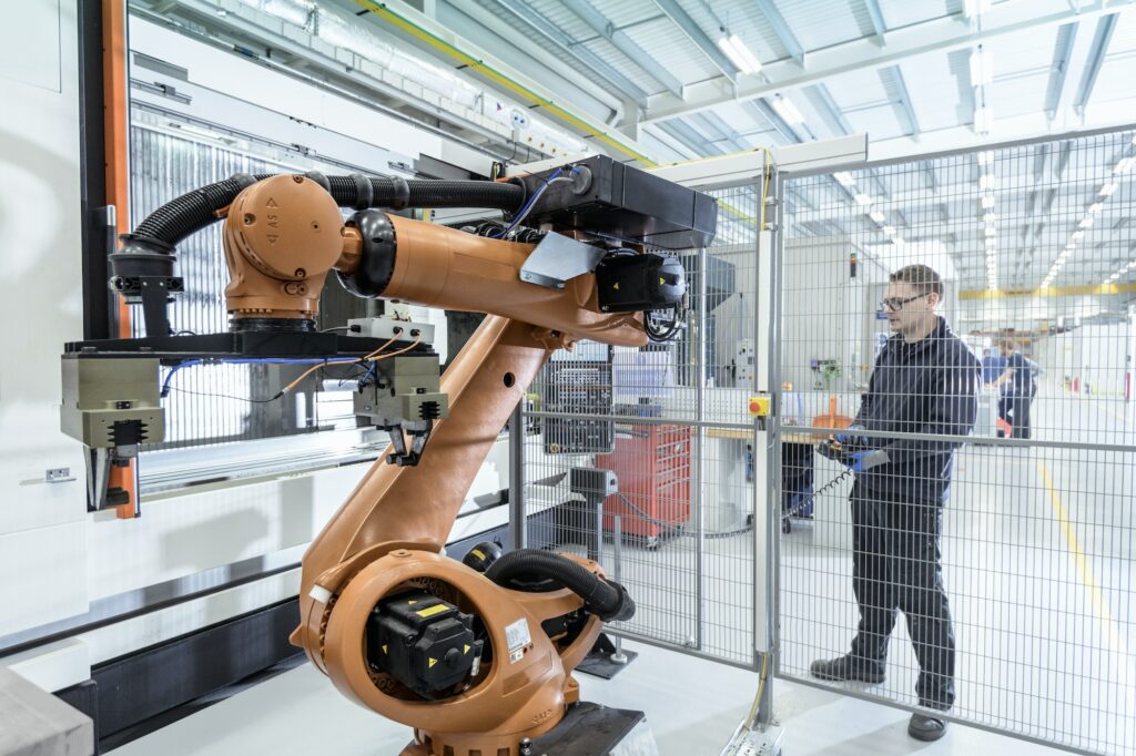 Robotics engineer operating robot aided CNC machine in robotics research facility